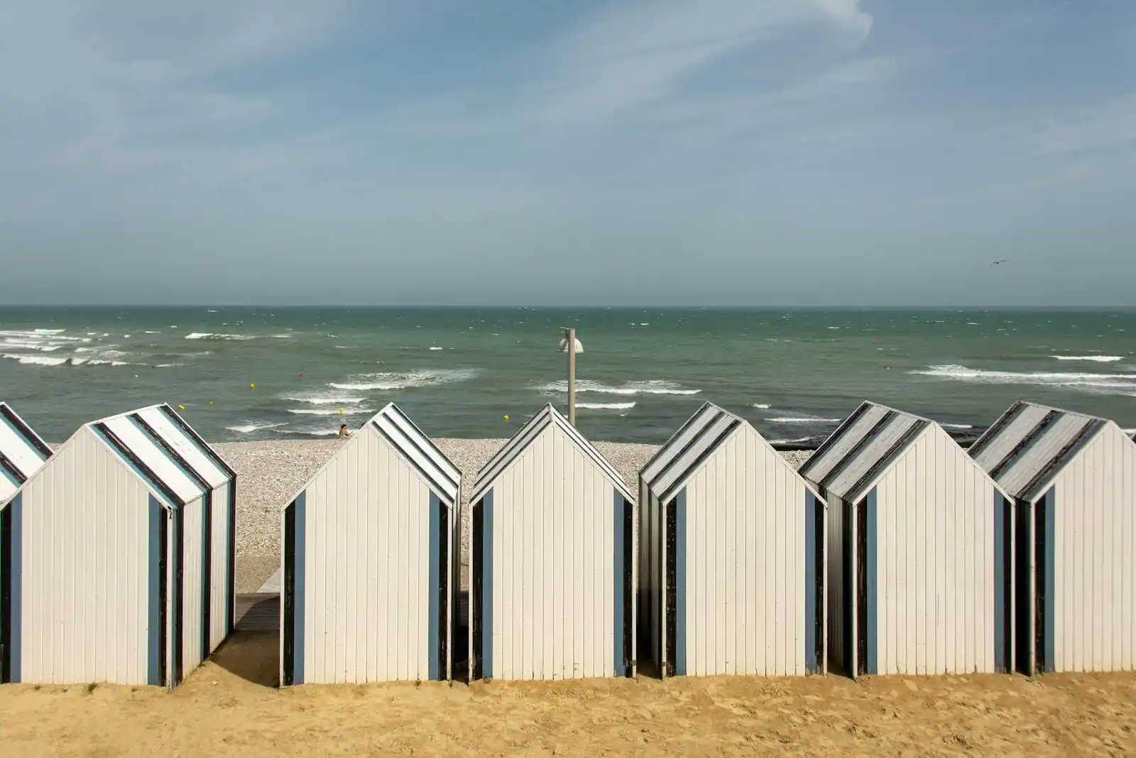 Hôtel de charme normand avec façade typique et jardin arboré, en lumière de fin de journée, ambiance authentique.