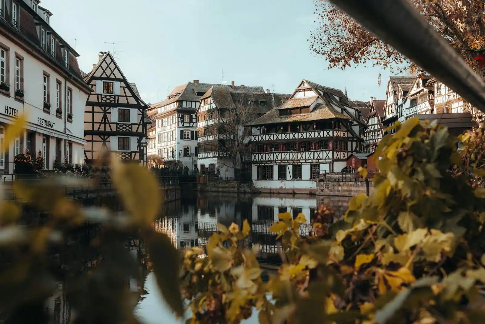 Canaux et maisons à colombages du quartier de la Petite France à Strasbourg en lumière douce, reflets dans l'eau.