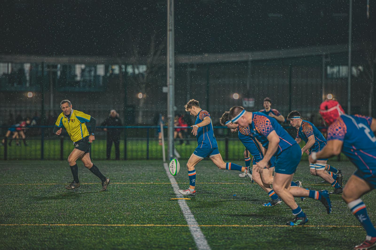 Action de rugby sur la pelouse d'un stade rempli, joueurs en mêlée