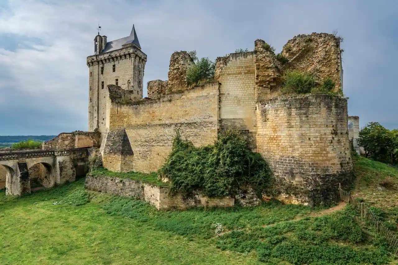 Château de Chinon sous un ciel pluvieux, pierre claire et nuages bas, ambiance médiévale humide