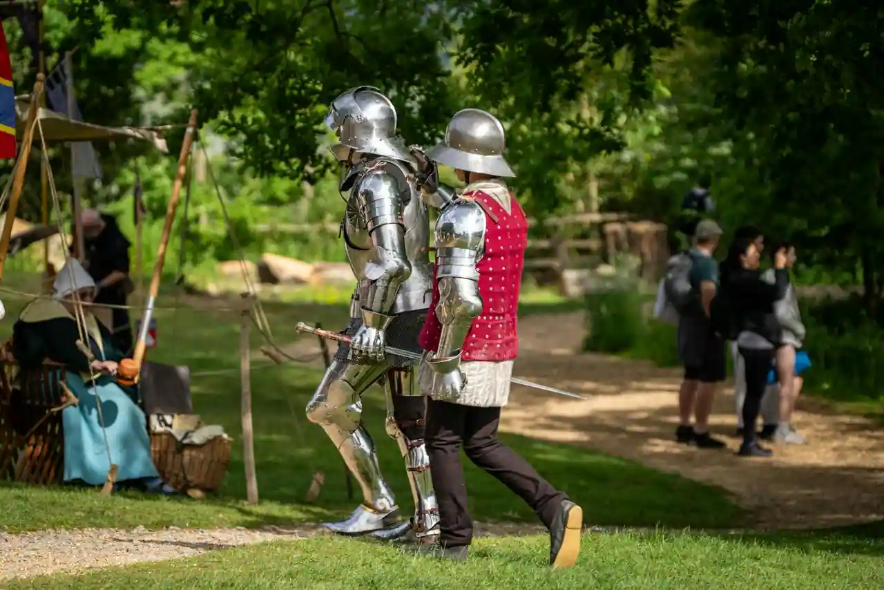 Reconstitution de tournoi médiéval avec chevaliers en armures et chevaux dans une cité historique