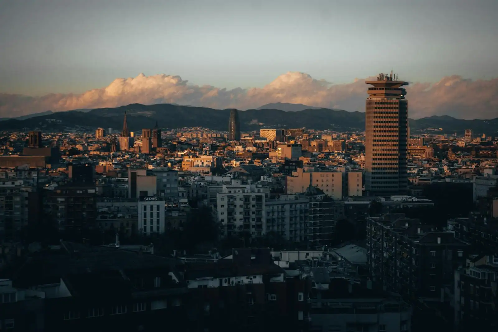 Vue sur les toits de Barcelone et la mer Méditerranée au coucher du soleil depuis une terrasse
