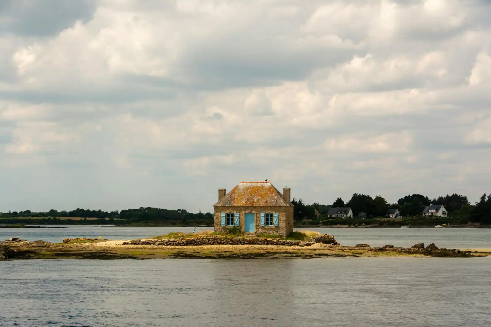 Maison de pêcheur en pierre face à la mer en Bretagne, lumière douce du matin sur la côte