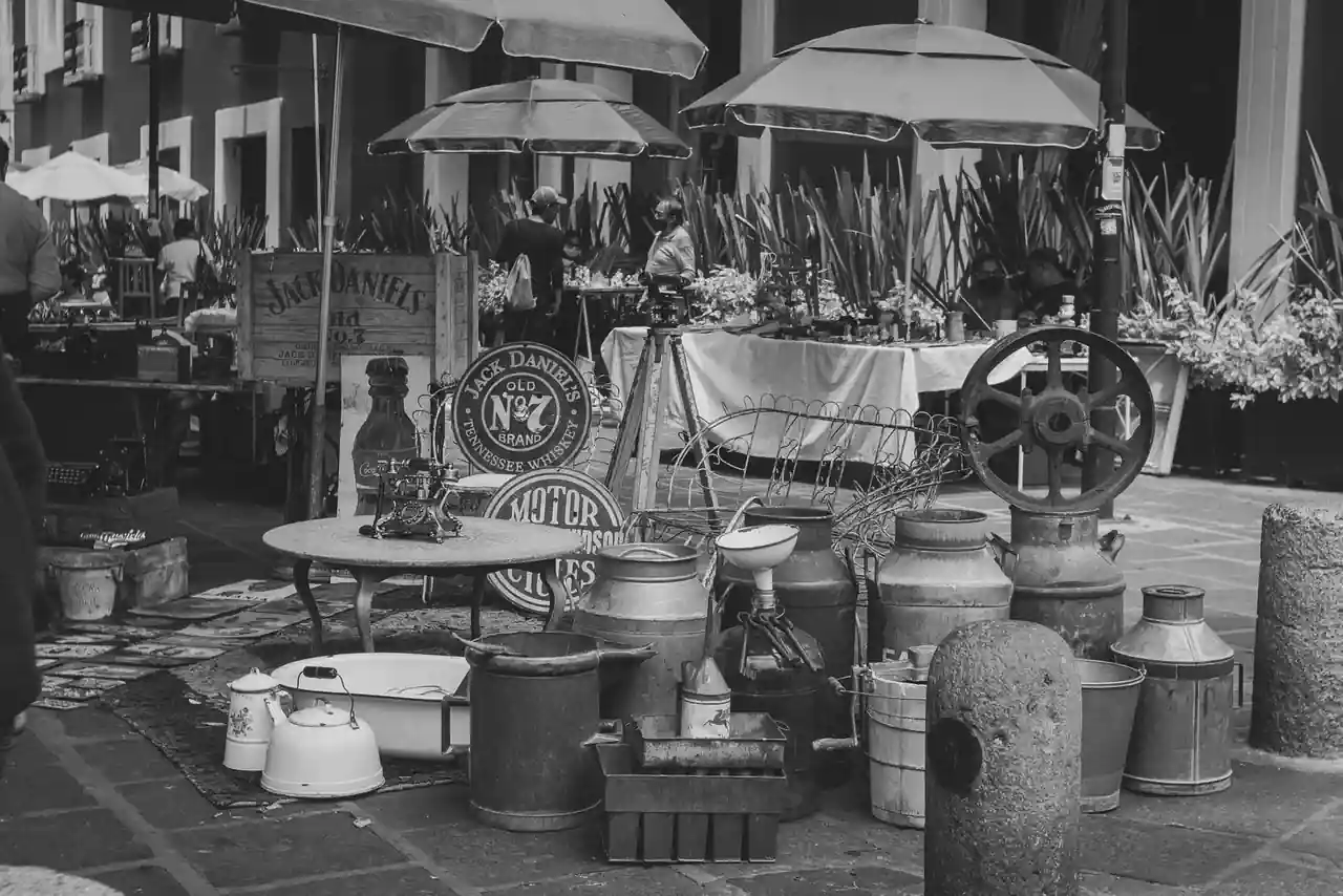 Stand de brocante alsacienne avec mobilier ancien, vaisselle vernissée et objets chinés en plein air