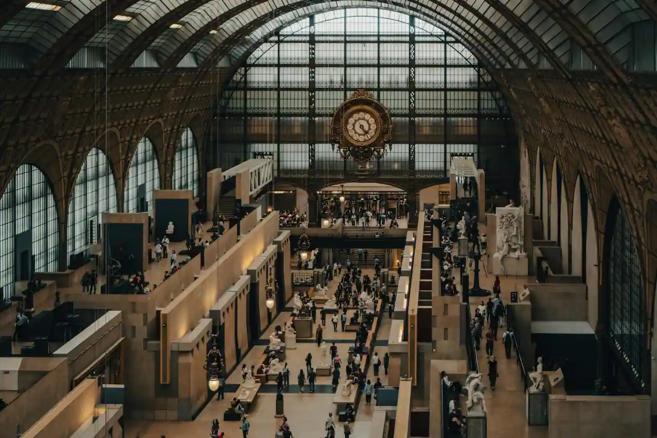 Galerie d'un musée parisien lumineux avec visiteurs devant des œuvres encadrées