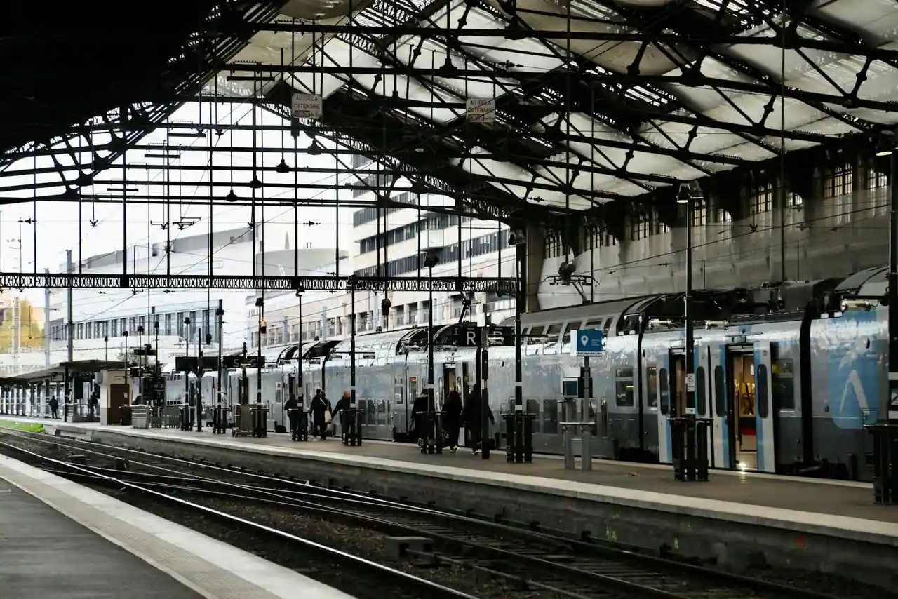 Quai de gare RER moderne à Nanterre, train arrivant, perspective vers les tours de La Défense au loin
