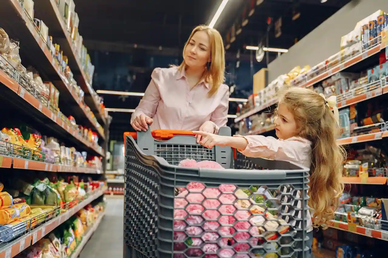 Rayons garnis et chariot dans l'allée d'un supermarché, ambiance de courses du quotidien