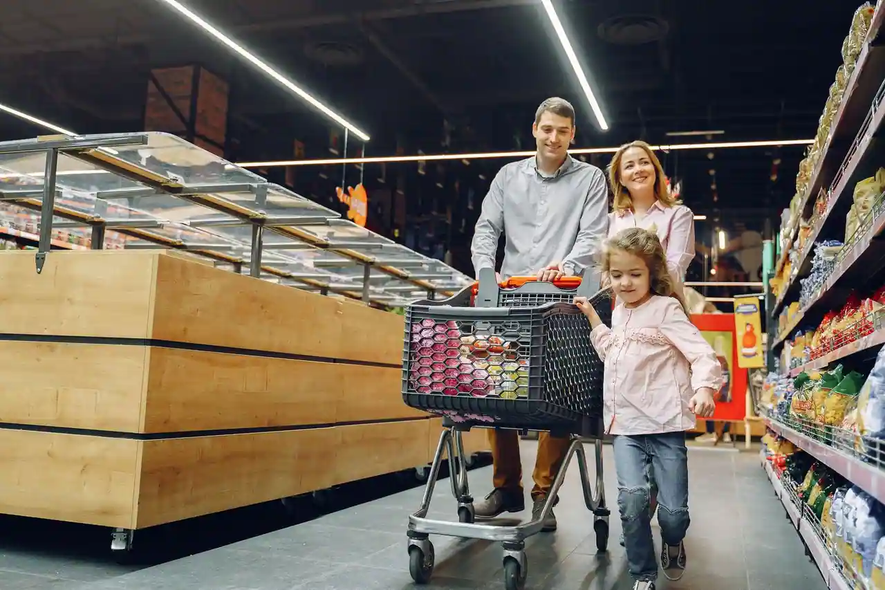 Caddie de supermarché devant un rayon avec étiquettes promotionnelles jaunes