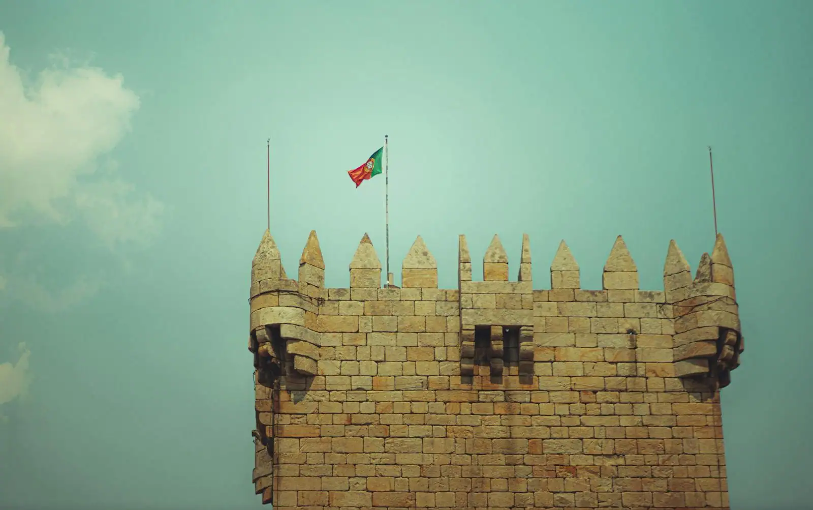 Château breton médiéval en granit avec drapeau gwenn ha du, ciel atlantique nuageux