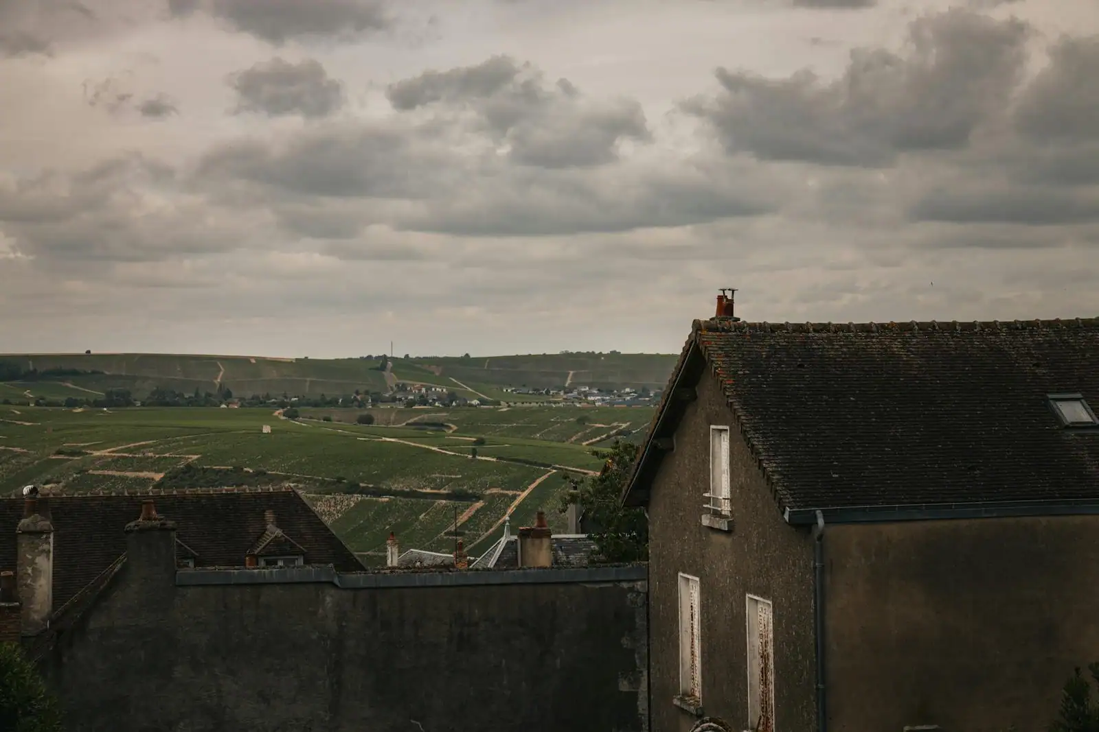 Paysage panoramique français vallonné aux lumières changeantes, évoquant la diversité des régions de France