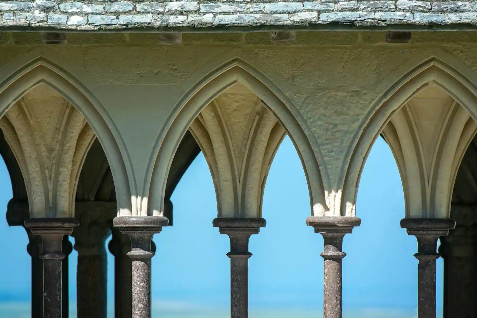 Cloître d'abbaye occitane au lever du soleil, lumière dorée sur la pierre, ambiance contemplative
