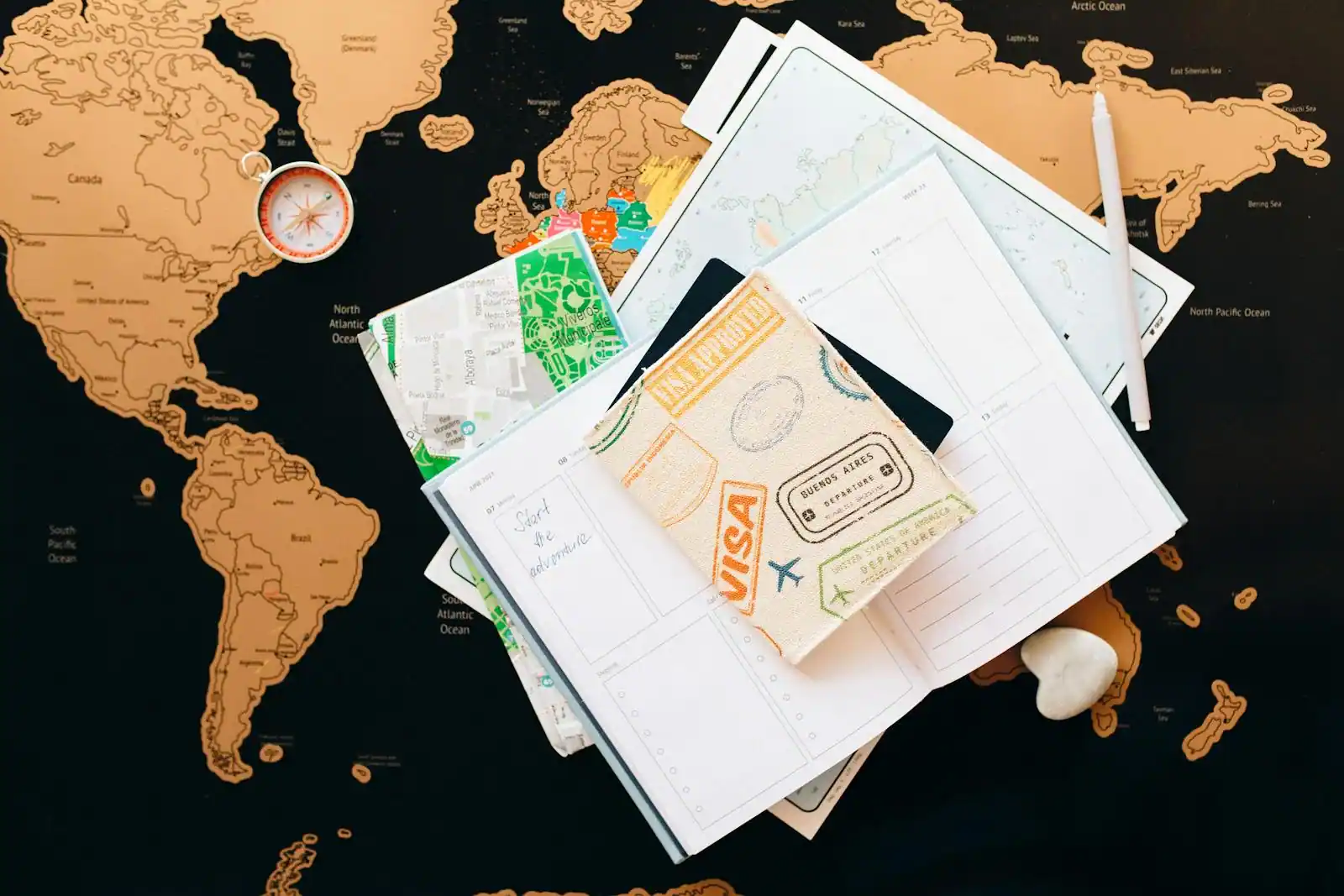 Carnet de voyage ouvert et passeport posés sur une carte papier d'Europe à la lumière du matin