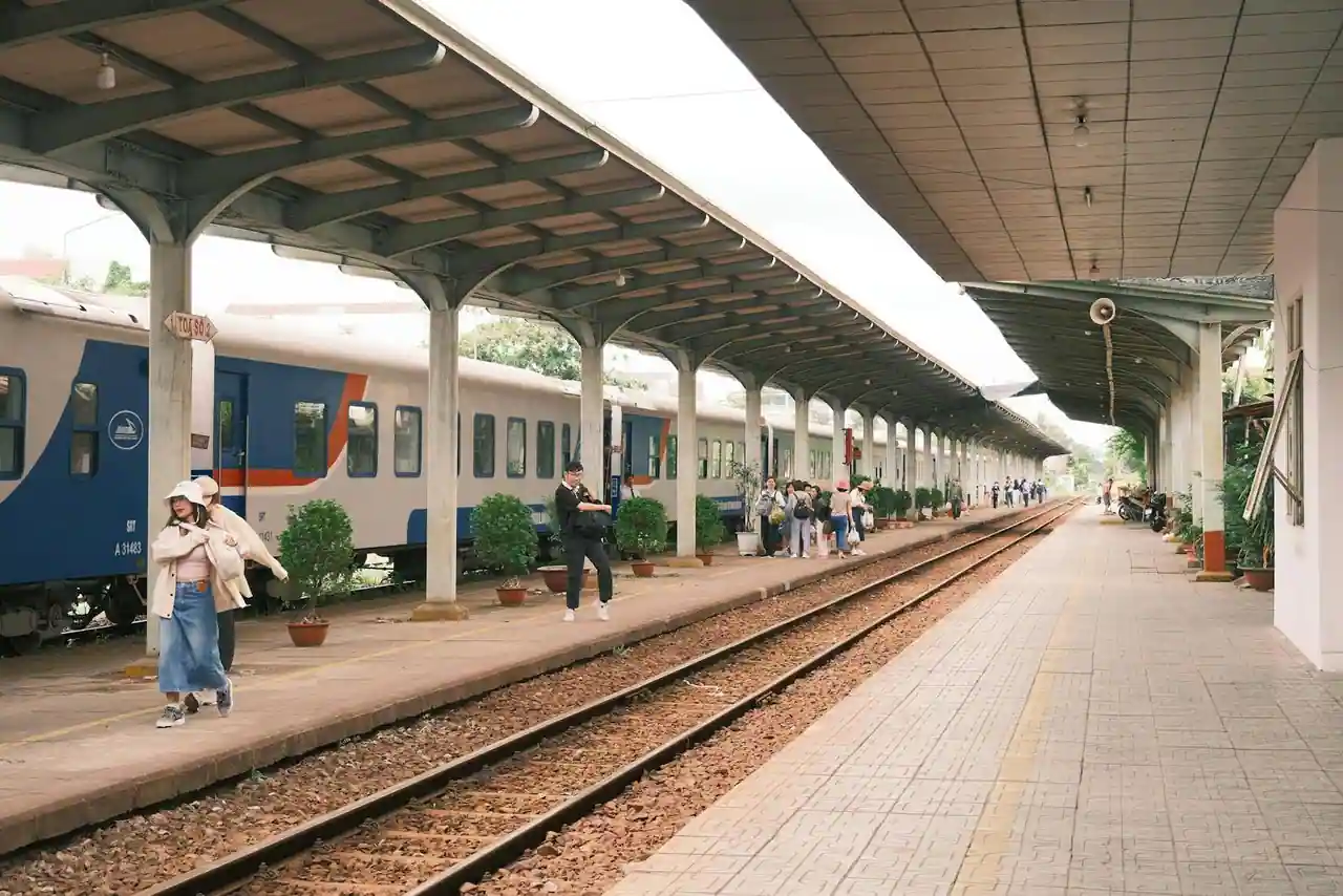 Train régional TER à quai dans une petite gare de campagne baignée de lumière du Sud