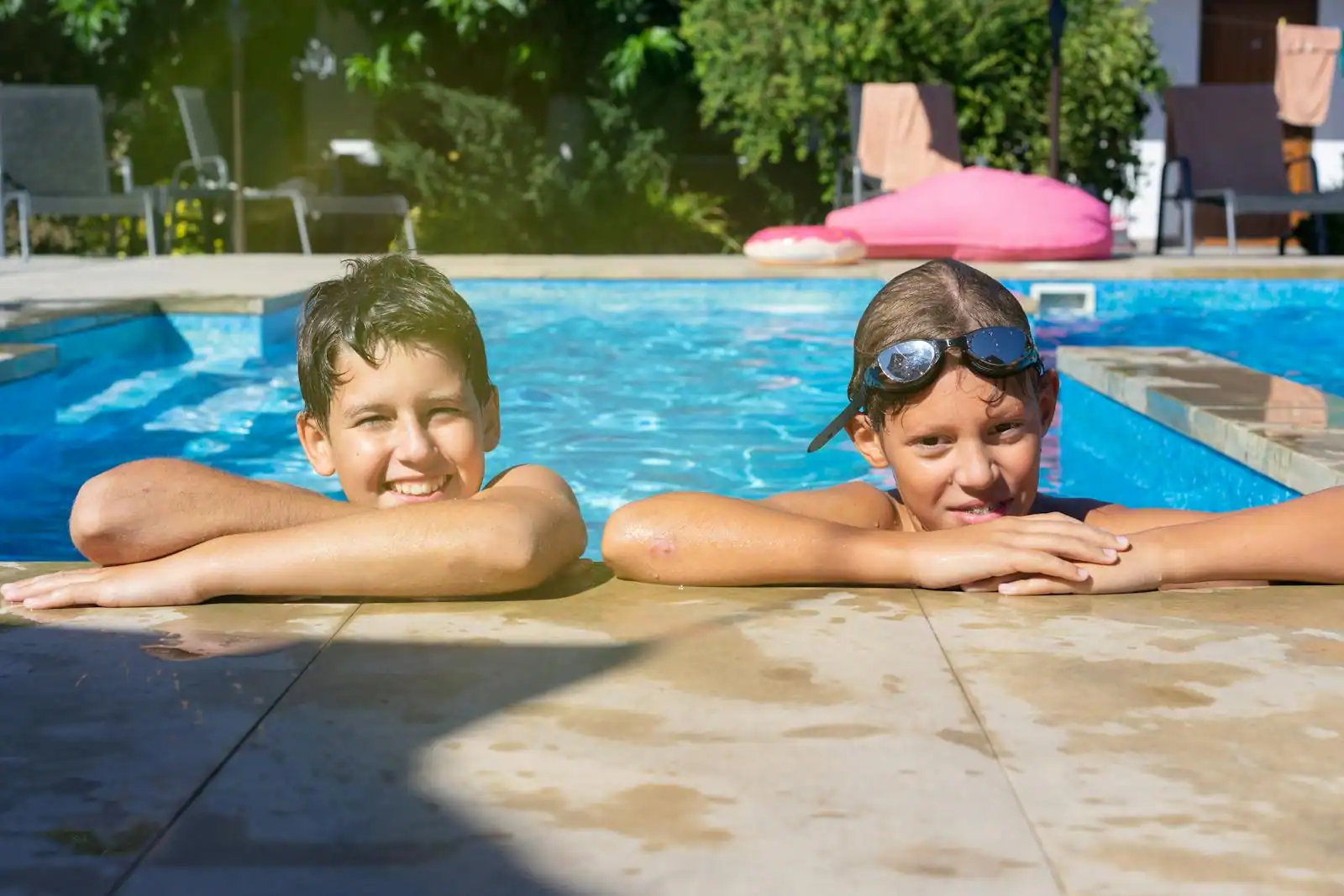 Famille avec deux enfants au bord de la piscine d'un club de vacances en bord de mer
