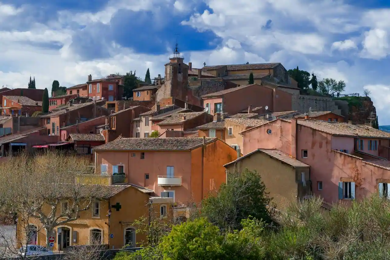 Falaises ocre rouge et jaune du village de Roussillon dans le Luberon, contraste avec les pins méditerranéens