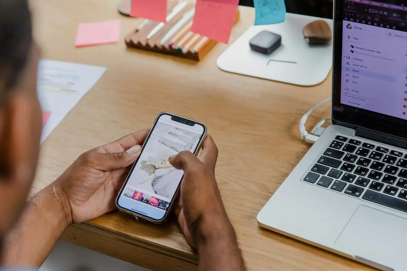 Ordinateur portable ouvert sur un service de fichiers en ligne, à côté d'une personne sur smartphone