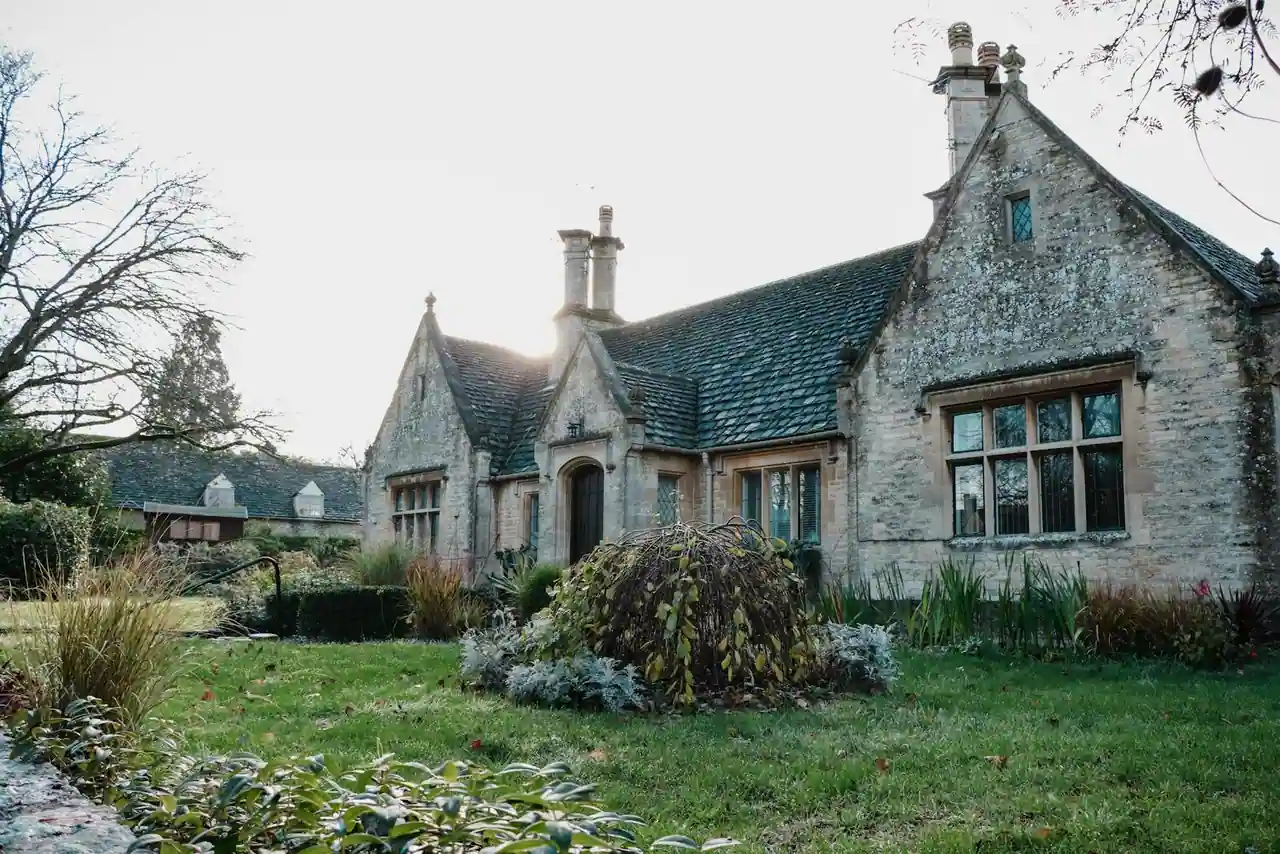 Maison de campagne en pierre avec jardin verdoyant, illustrant un hébergement rural de charme