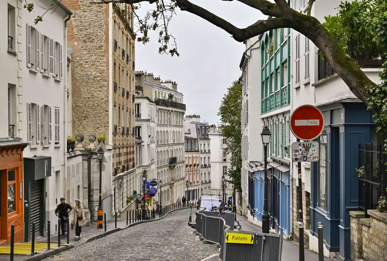 Rue pavée typique de Montmartre bordée d'immeubles parisiens classiques à Paris