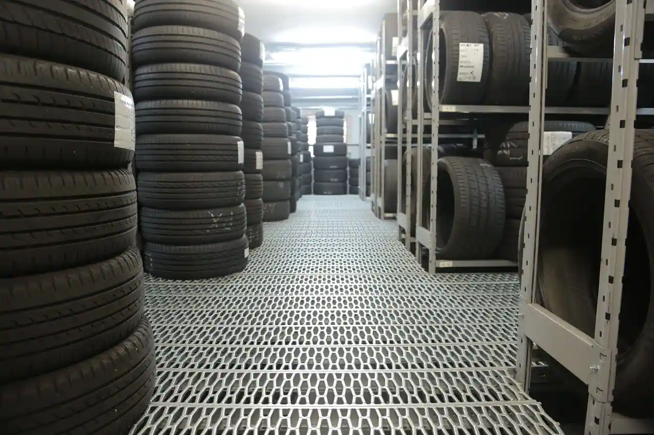 Pneus de voiture empilés sur des racks dans un point de vente spécialisé en pneumatiques.