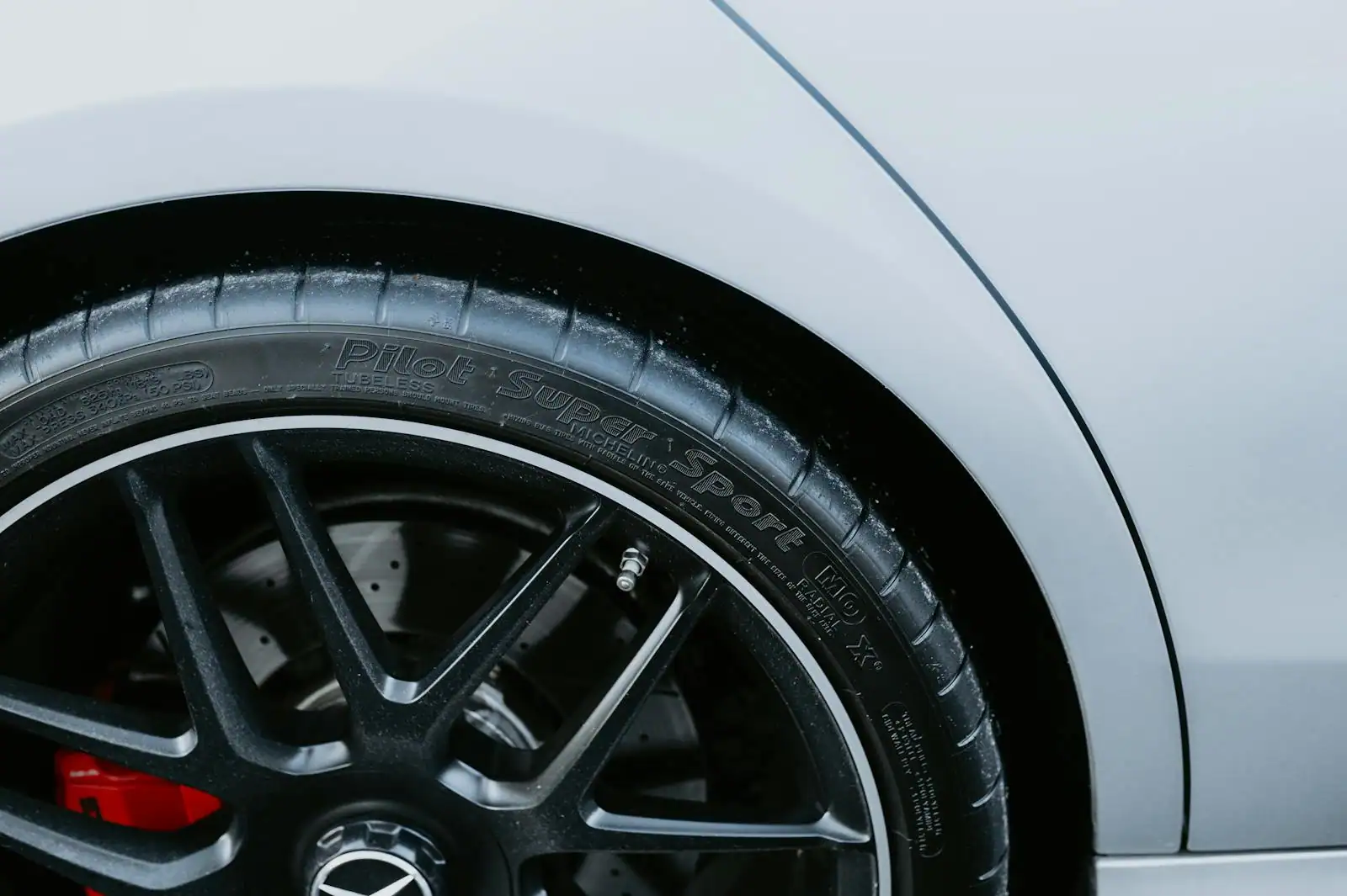 Gros plan d'une roue de voiture équipée de son pneu, flanc et sculpture visibles