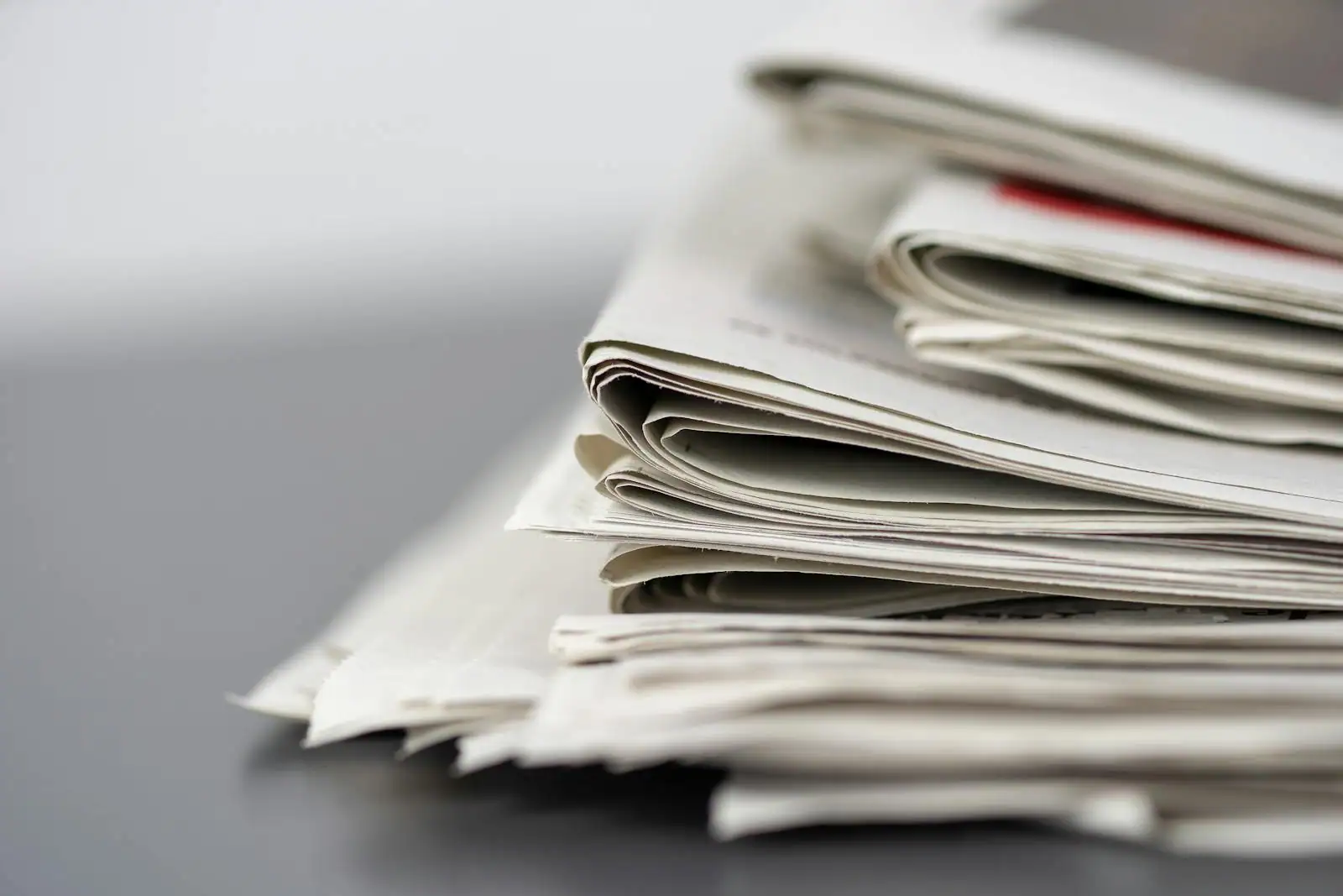 Plusieurs journaux internationaux pliés posés côte à côte sur une table