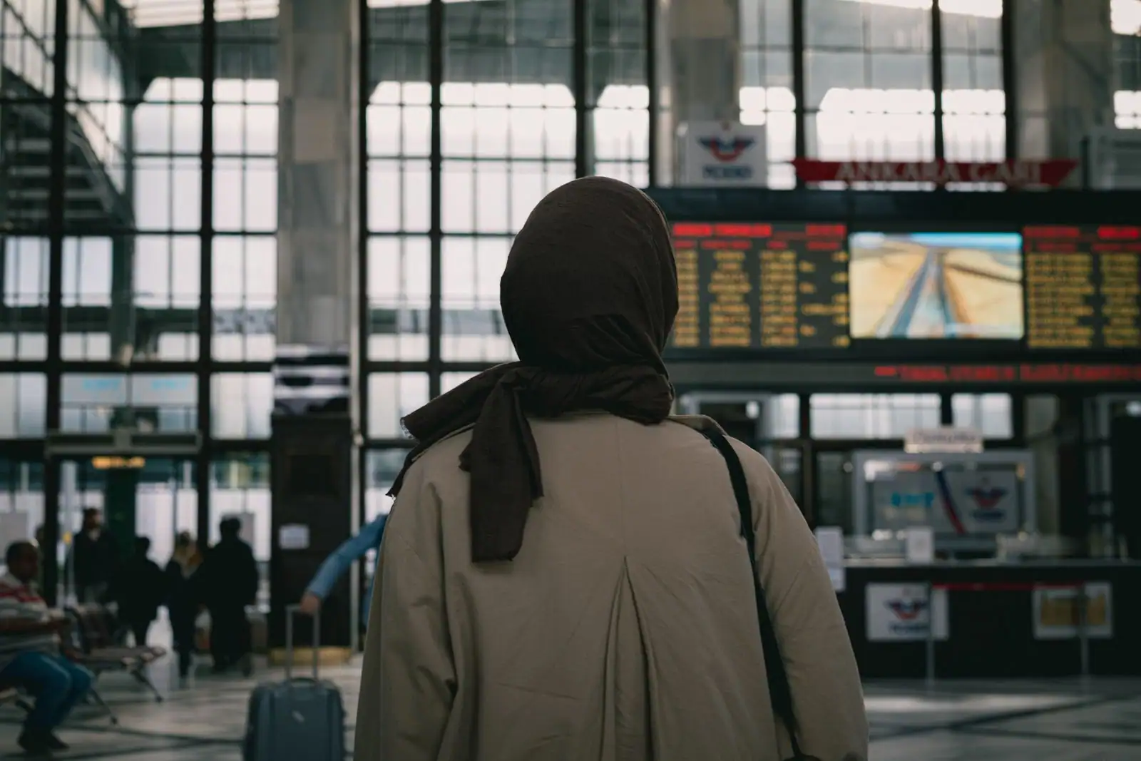 Voyageur consultant le panneau d'affichage des départs dans le hall d'une gare