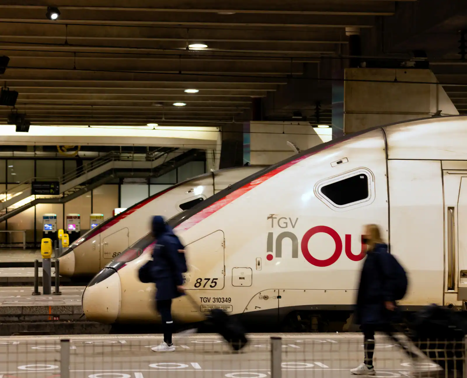 Rame de TGV inOui à quai dans une gare parisienne, voyageurs marchant sur le quai