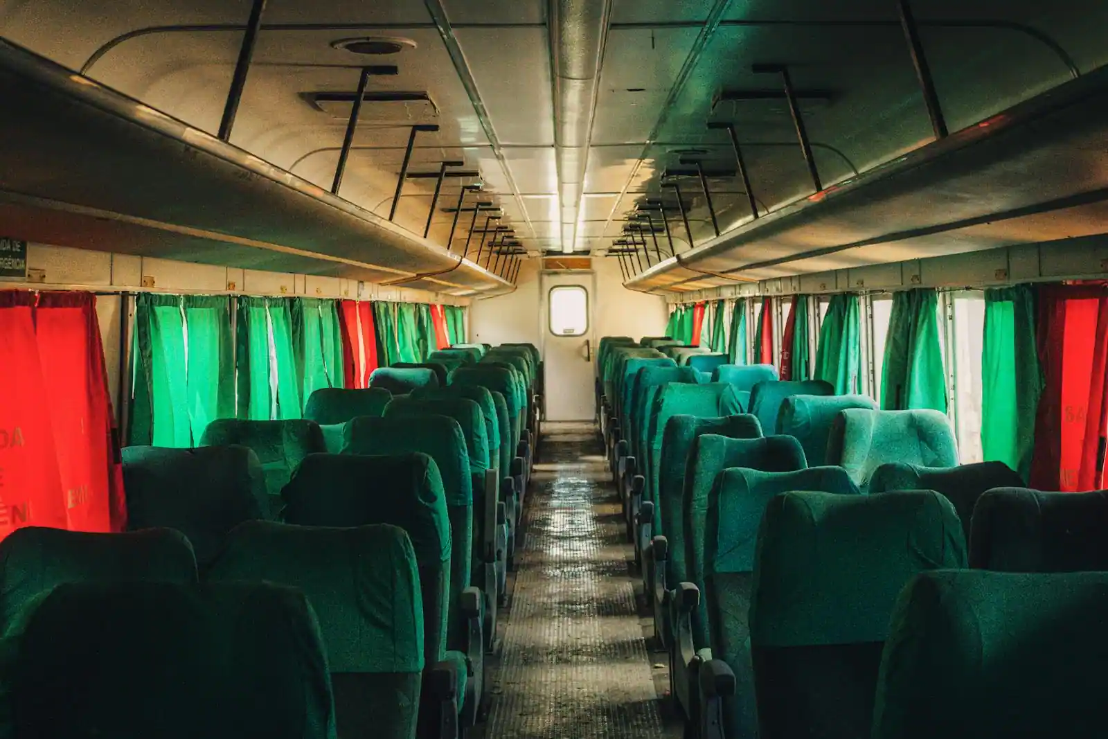 Compartiment couchette d'un train de nuit : couchettes repliées et fenêtre ouverte sur un paysage d'automne