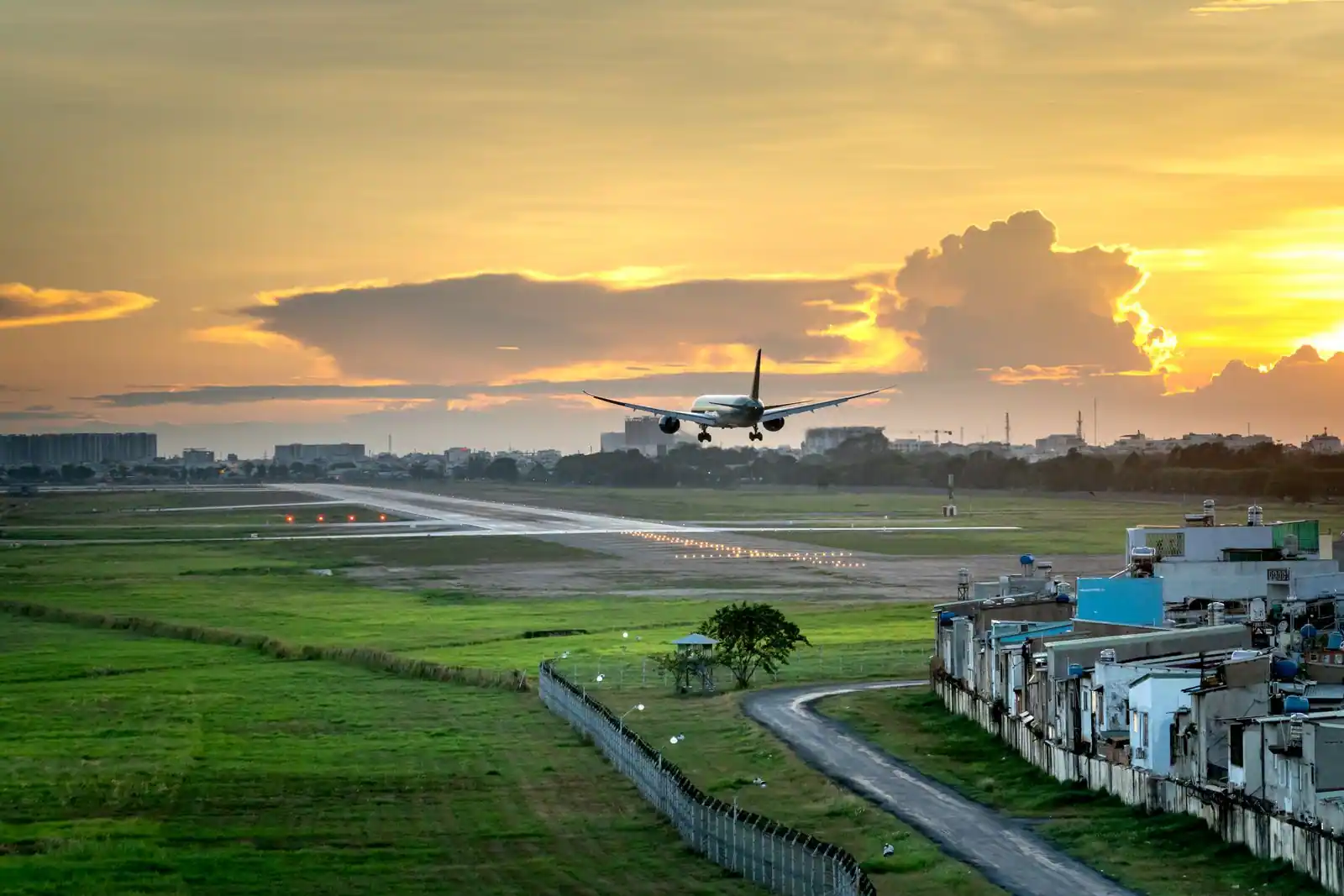 Avion de ligne au décollage au-dessus de la piste au coucher du soleil