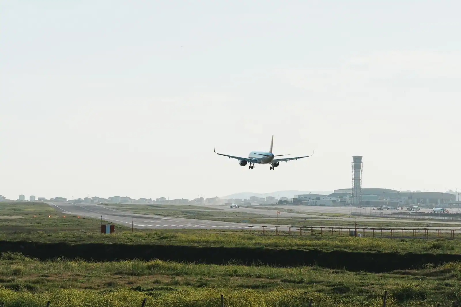 Avion de ligne en approche finale au-dessus de la piste d'un aéroport, train d'atterrissage sorti