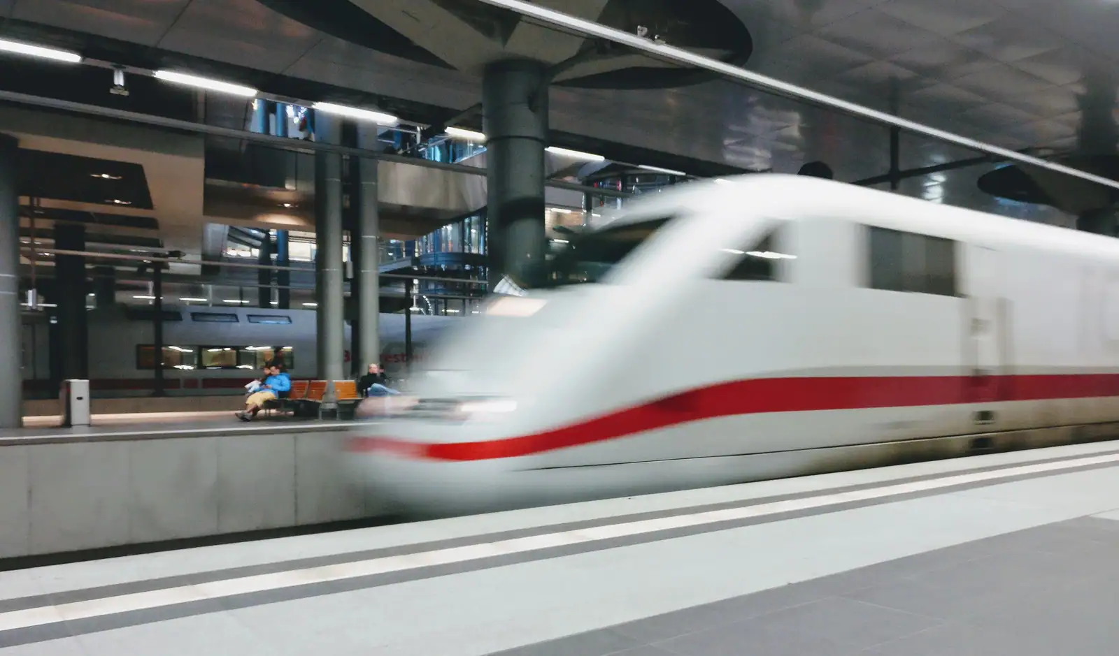 Train à grande vitesse filant le long d un quai dans une gare couverte moderne au départ