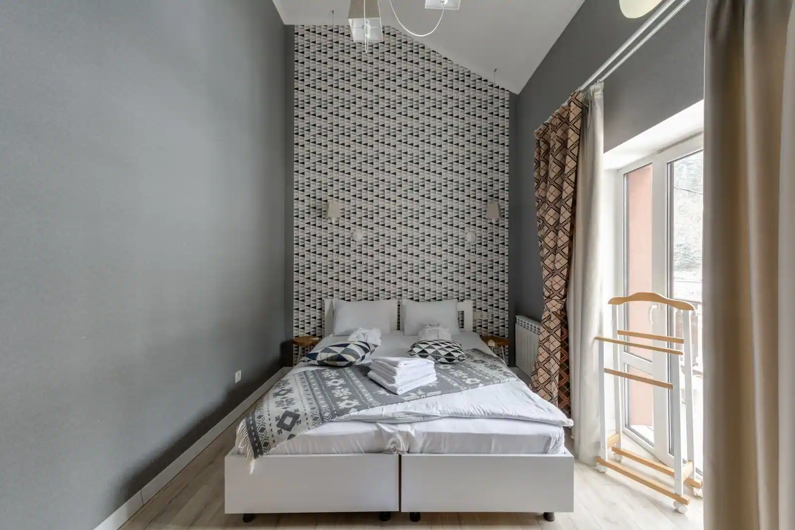 Chambre d'hôtel simple et lumineuse avec un lit double près d'une fenêtre