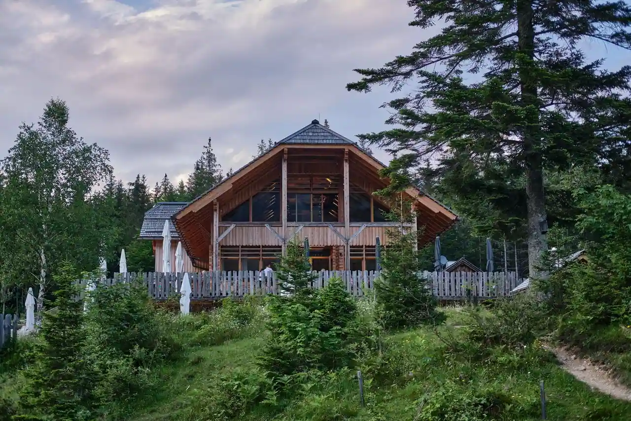 Bâtiment de style lodge forestier en bois, entouré de sapins, ambiance de chalet de montagne