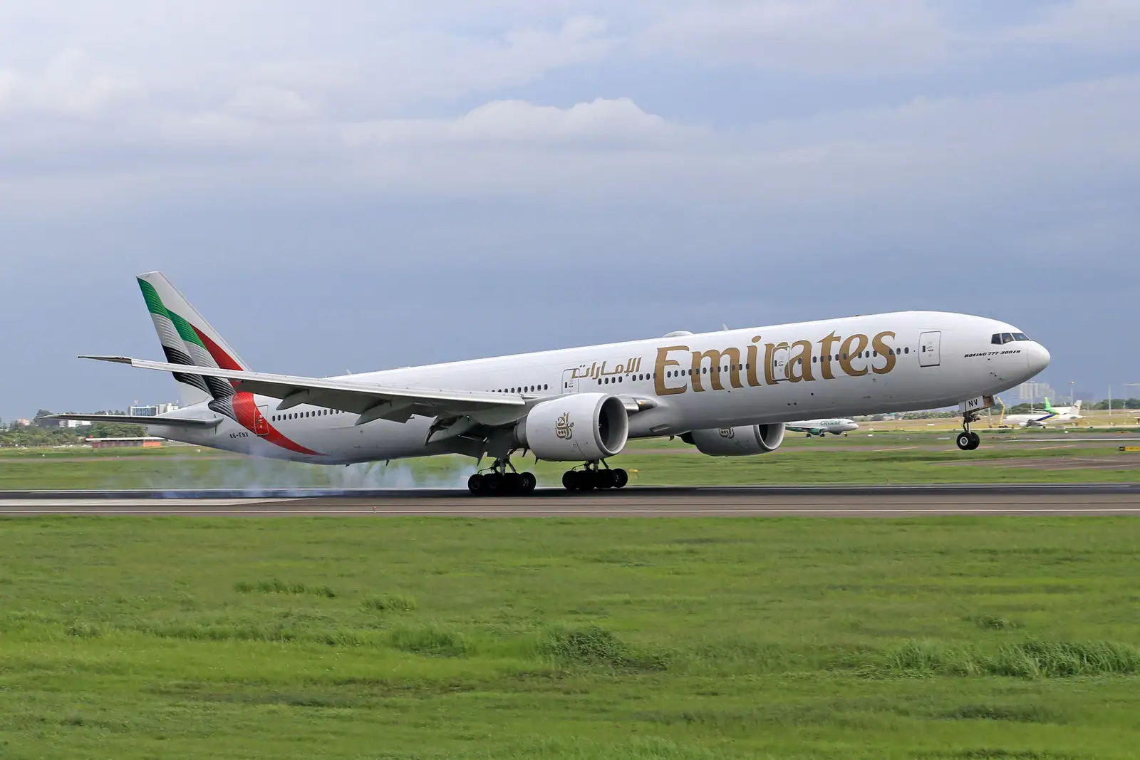 Avion gros-porteur de la compagnie Emirates sur la piste d'un aéroport, roues au contact du sol.