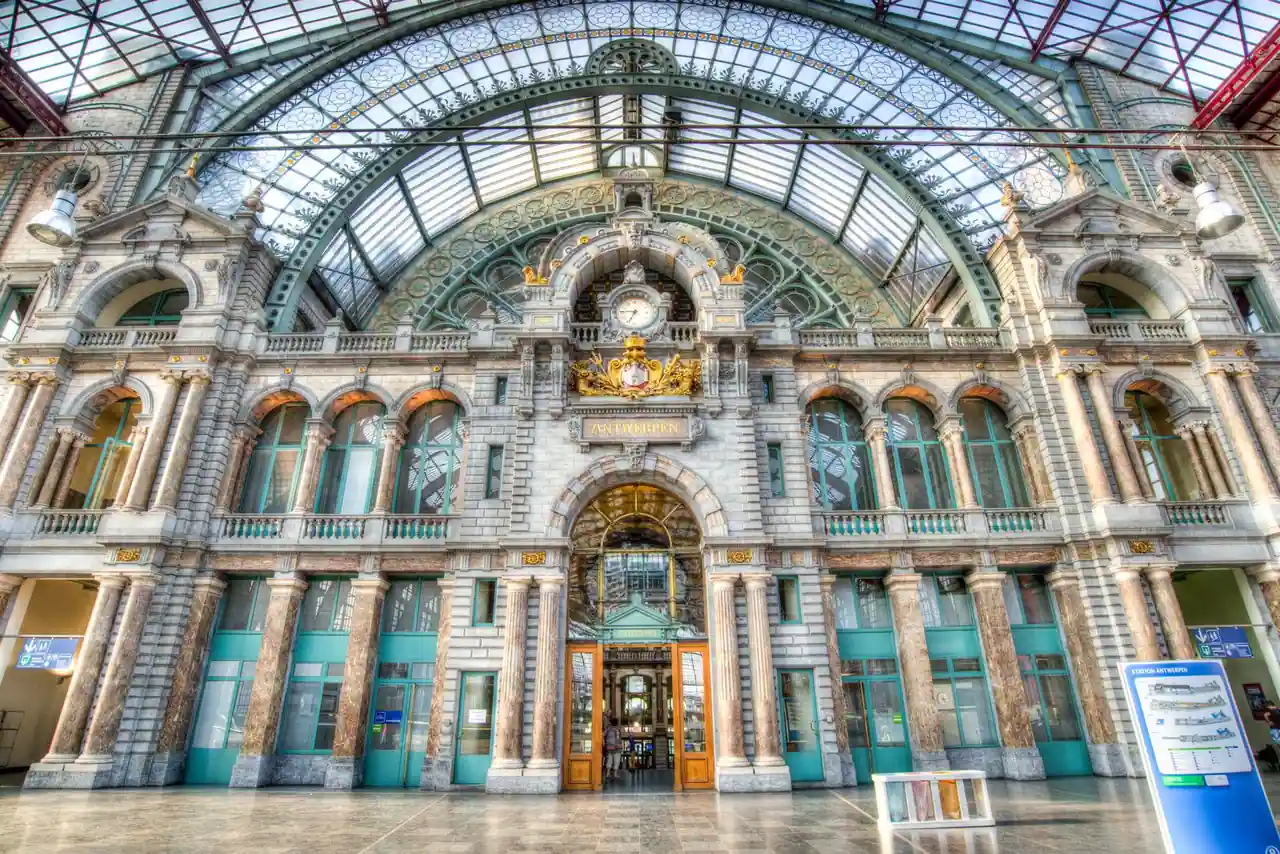 Hall de la gare d'Anvers-Central : façade de pierre ornée et grande verrière métallique en berceau