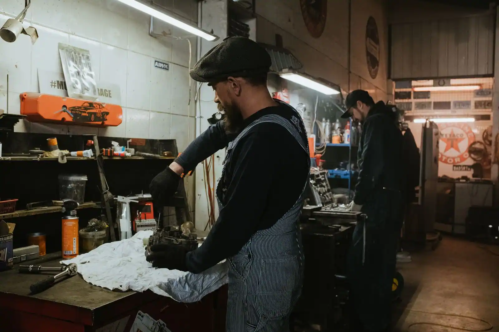 Mécaniciens au travail sur des pièces automobiles dans l atelier d un garage.