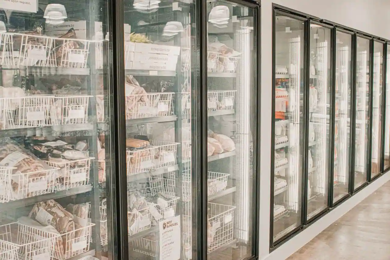 Armoires vitrées réfrigérées d'un magasin, remplies de produits surgelés emballés