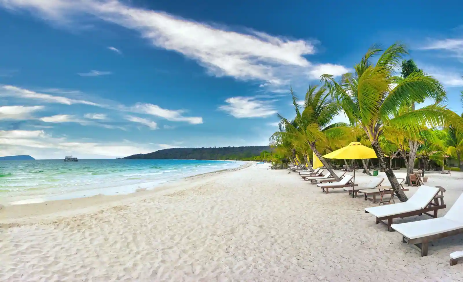 Plage de sable bordée d'une mer turquoise et de parasols, évoquant une destination de vacances au soleil