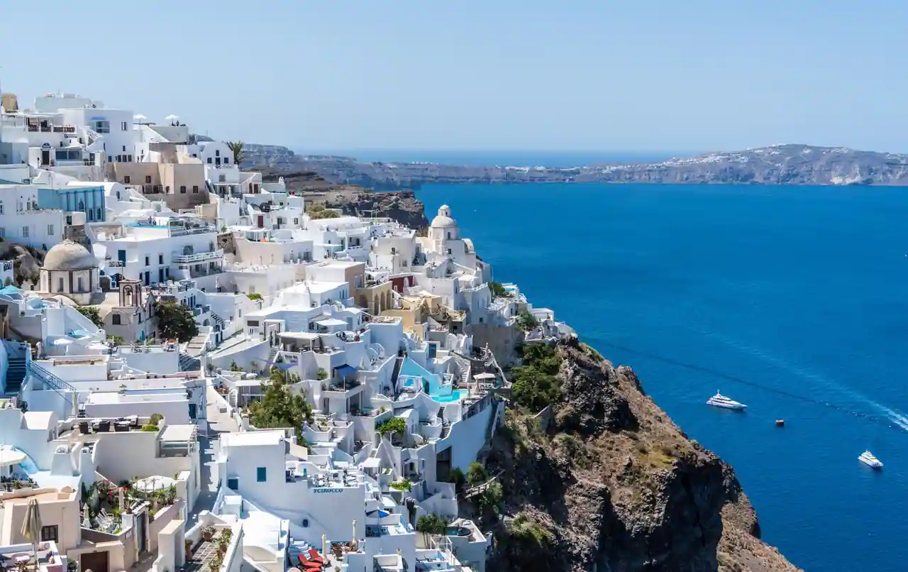 Village grec aux maisons blanches perché sur une falaise surplombant la mer Égée